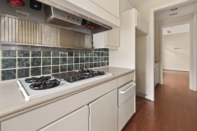 a kitchen with a sink cabinets and wooden floor