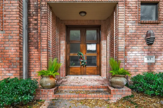 a front view of a house with potted plants