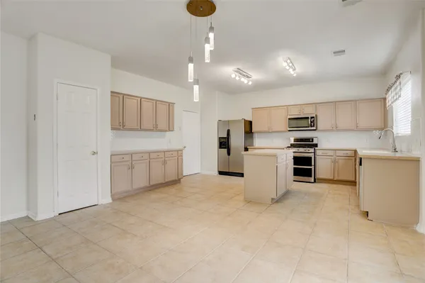 a kitchen with refrigerator and cabinets