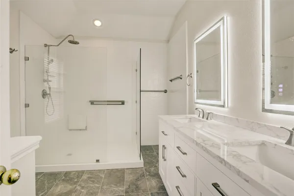 a bathroom with a granite countertop sink mirror and shower