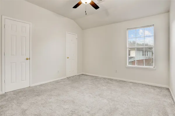 an empty room with chandelier fan