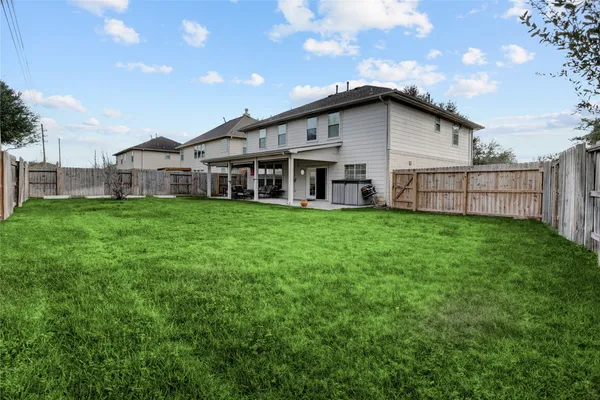 a view of a house with a big yard and large trees