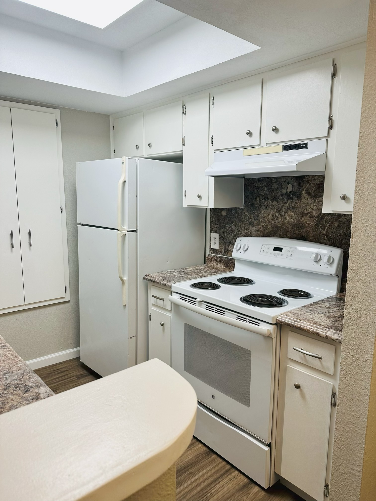 245 Mt Olive Road, Unit A & B Cedar Creek, TX 78612 - Photo 20 of 33 Unit A Kitchen with white range with electric cooktop, decorative backsplash, white cabinetry, and dark wood-style floors