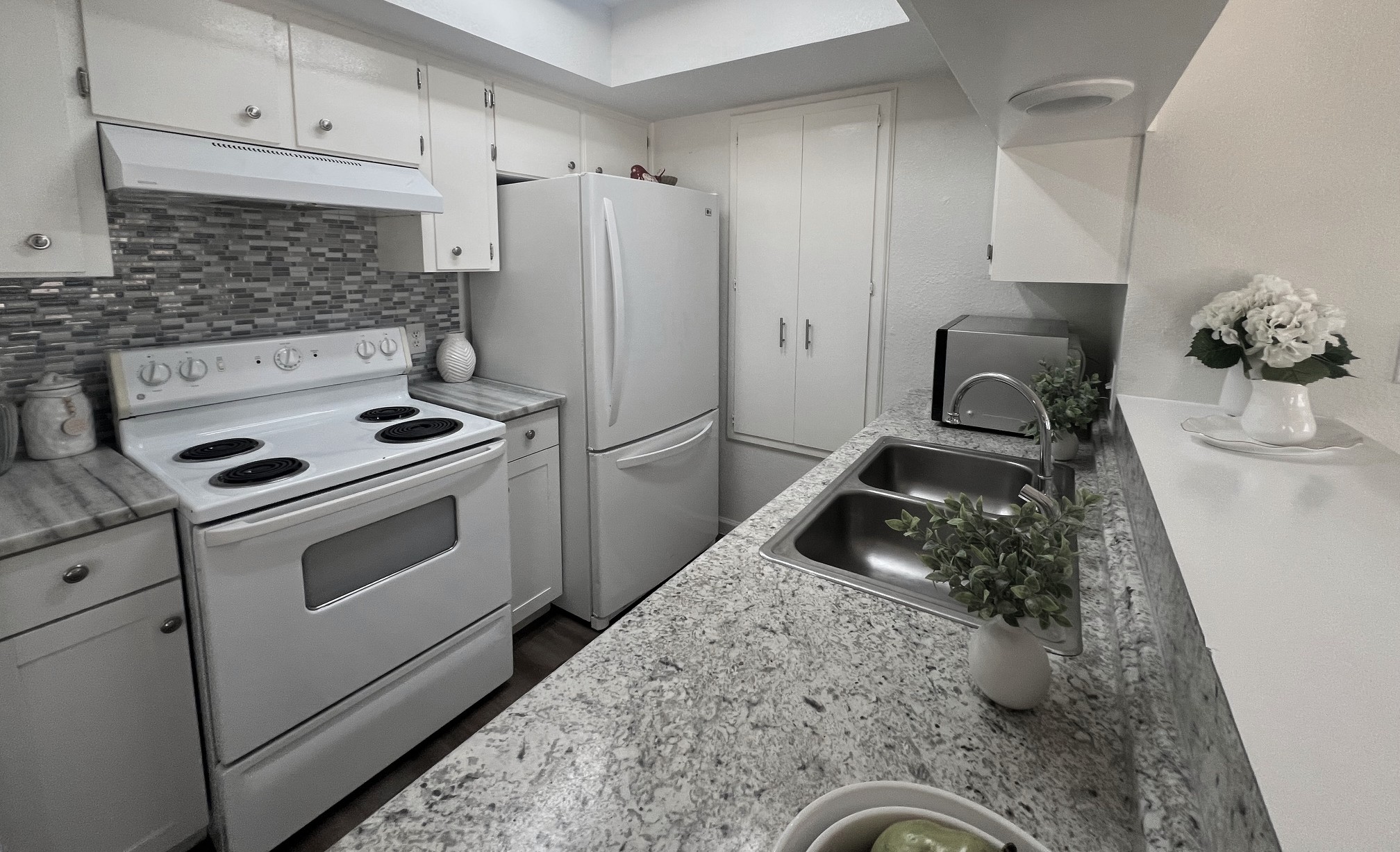245 Mt Olive Road, Unit A & B Cedar Creek, TX 78612 - Photo 6 of 33 Kitchen with white appliances, white cabinetry, and tasteful backsplash