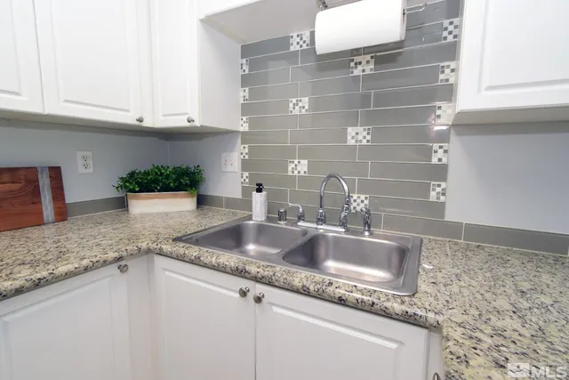 a kitchen with granite countertop a sink and cabinets