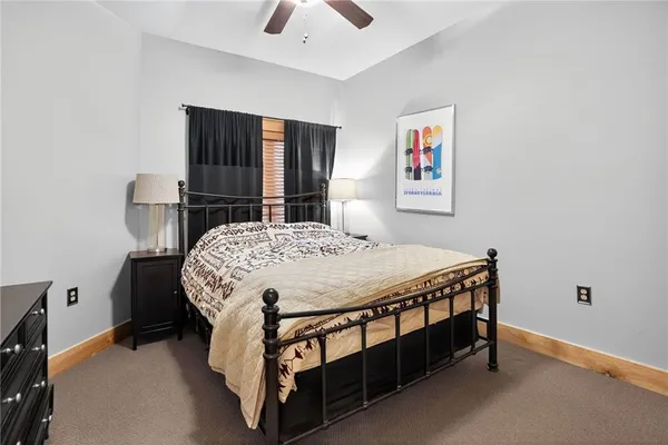 a bed sitting in a bedroom next to a window with pc on the wall