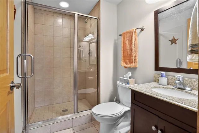 a bathroom with a granite countertop sink toilet and shower