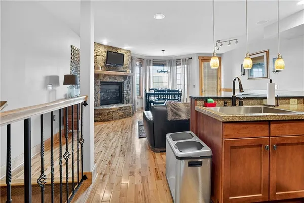 a kitchen with kitchen island granite countertop a stove and a wooden floors