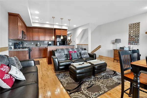 a living room with furniture kitchen view and a chandelier