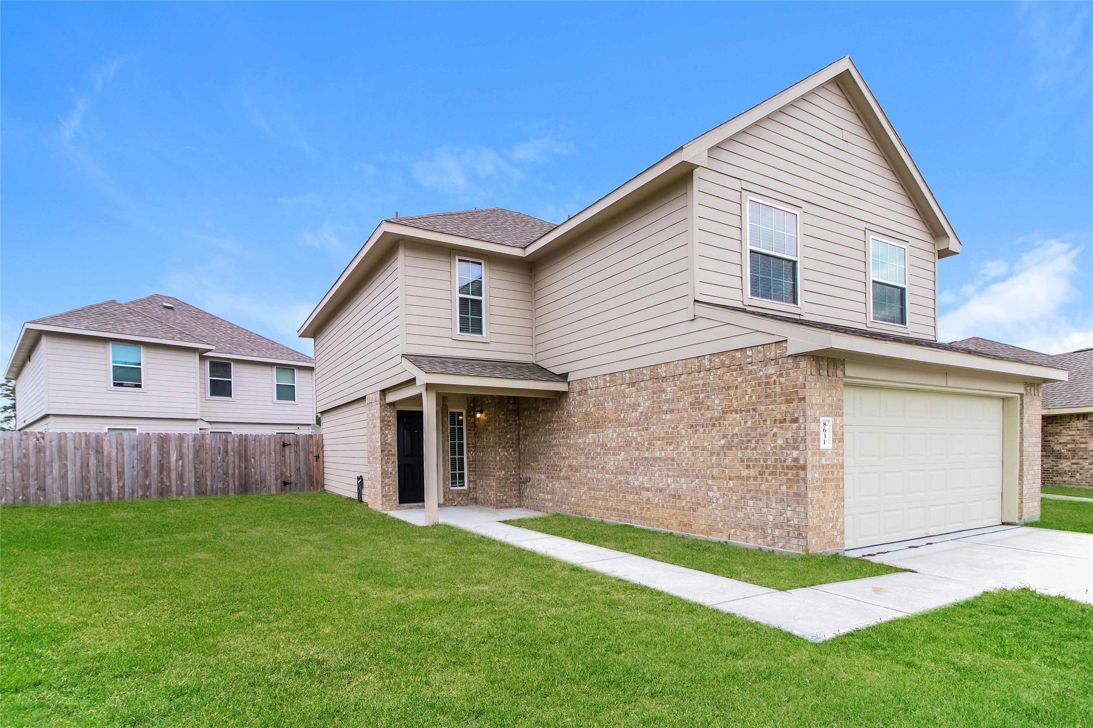 8631 Doris Oaks Circle Houston, TX 77028 - Photo 2 of 11 a front view of a house with a yard and garage