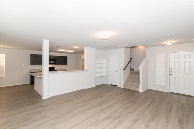 a view of a kitchen with wooden floor and electronic appliances