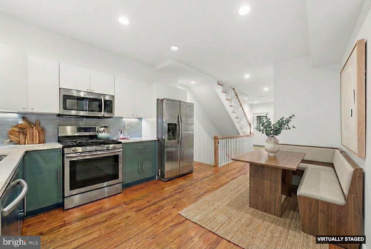 a kitchen with stainless steel appliances kitchen island granite countertop a sink a stove top oven a counter space and cabinets