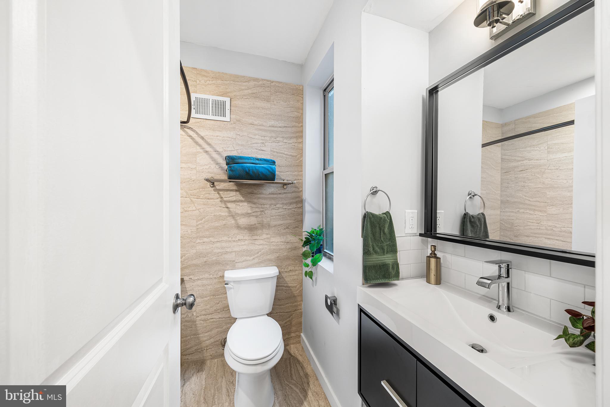 1346 South 46th Street Philadelphia, PA 19143 - Photo 14 of 32 a bathroom with a sink mirror vanity and toilet