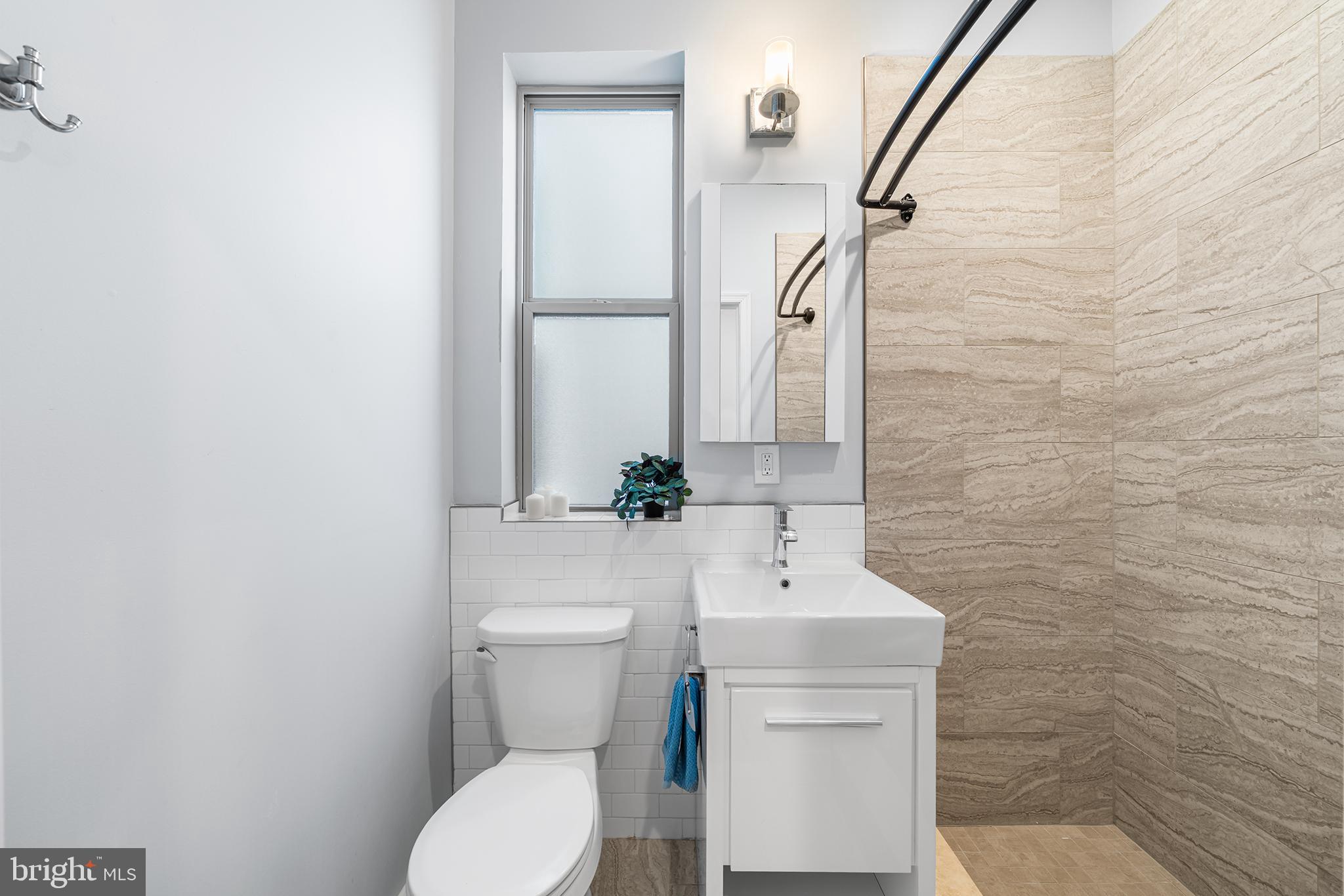 1346 South 46th Street Philadelphia, PA 19143 - Photo 21 of 32 a bathroom with a sink a toilet and mirror