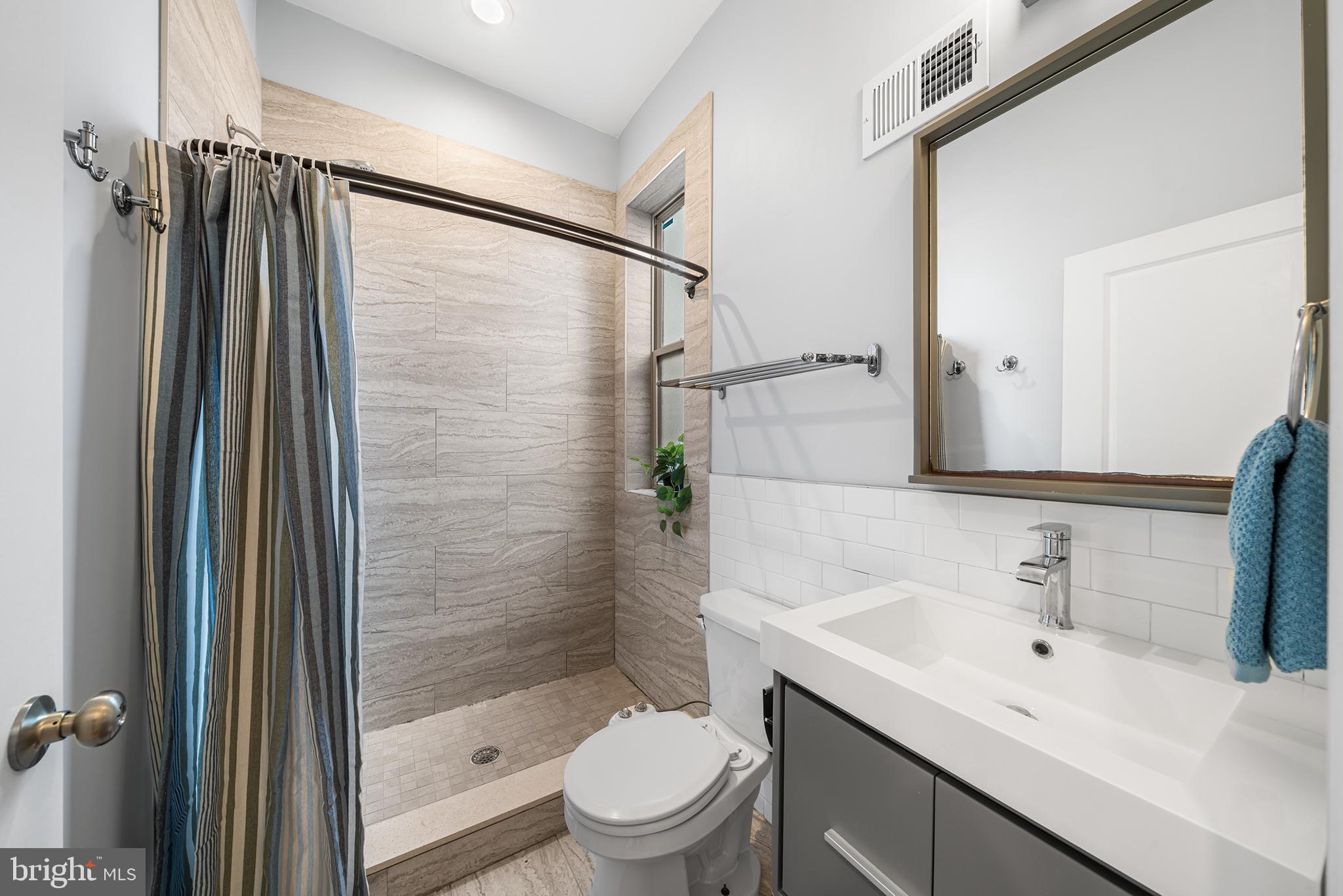 1346 South 46th Street Philadelphia, PA 19143 - Photo 25 of 32 a bathroom with a shower sink vanity mirror and toilet