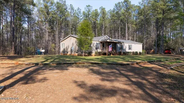a view of large house with a big yard and large trees