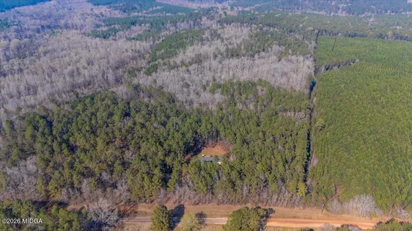 a view of a house with a yard and large trees
