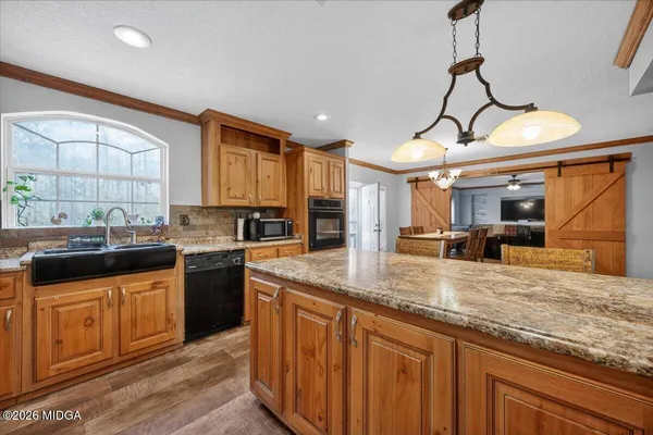 a kitchen with stainless steel appliances granite countertop a sink a stove and a wooden floors