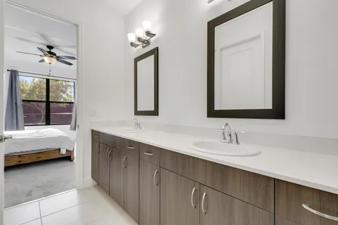 a bathroom with double vanity sinks and a mirror