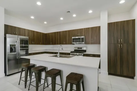 a kitchen with stainless steel appliances granite countertop a sink and a refrigerator