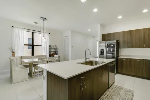 a kitchen with stainless steel appliances granite countertop a sink a stove and a refrigerator