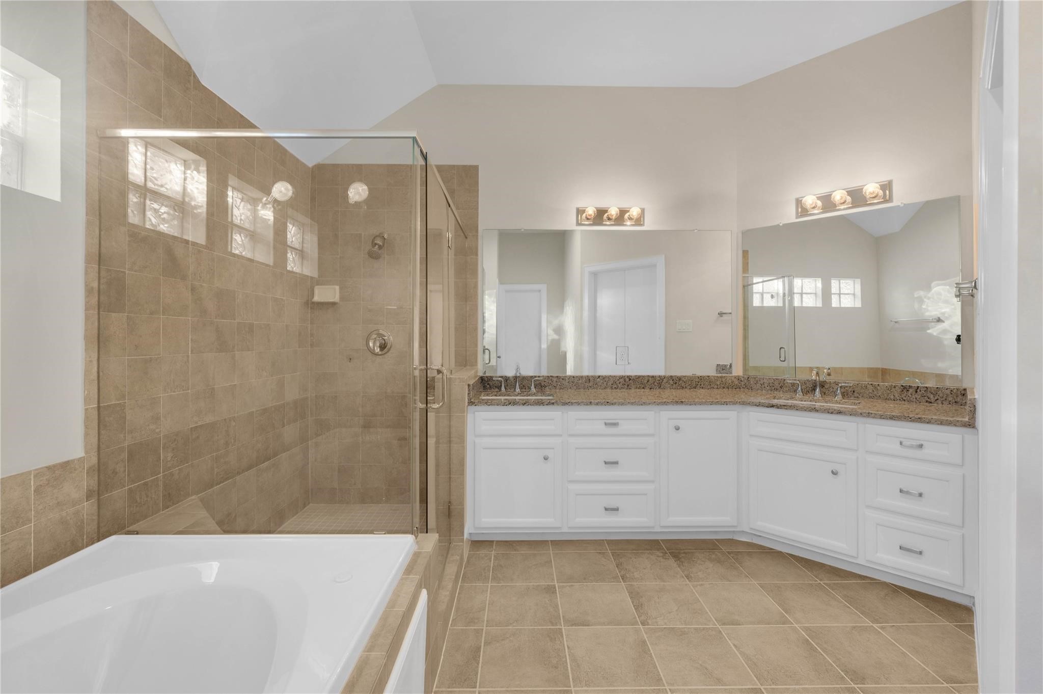 8731 Bryam Houston, TX 77061 - Photo 15 of 19 a spacious bathroom with a granite countertop sink a mirror a bathtub and a shower