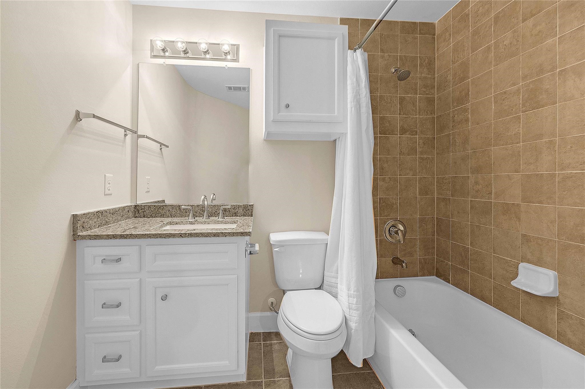 8731 Bryam Houston, TX 77061 - Photo 5 of 19 a bathroom with a granite countertop toilet a sink and bathtub