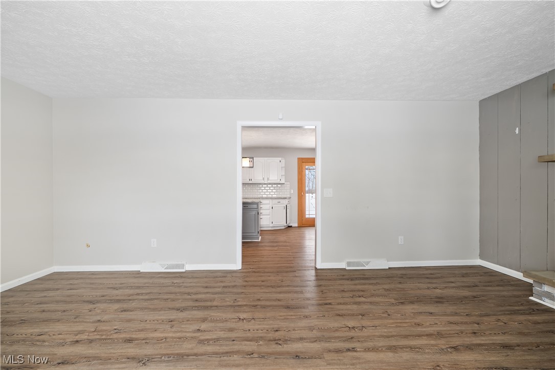 6059 Branch Road Medina, OH 44256 - Photo 6 of 39 Unfurnished room with a textured ceiling, dark wood-type flooring, visible vents, and baseboards