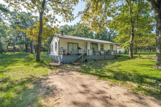 a view of a house with backyard and a tree