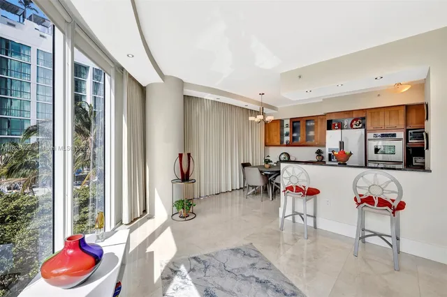 a living room with furniture a flat screen tv and a floor to ceiling window