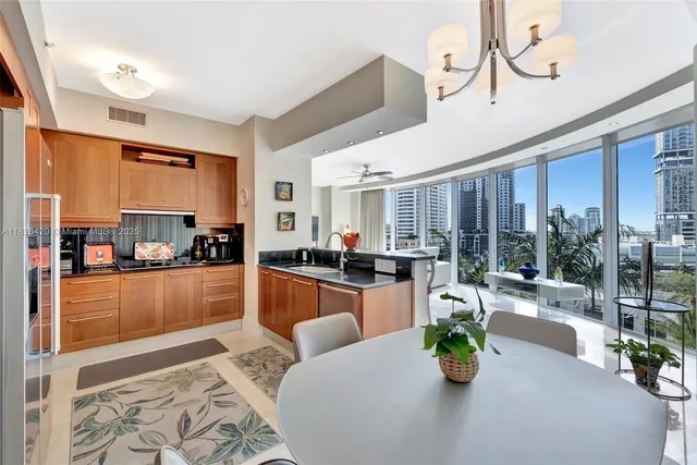 a large living room with stainless steel appliances furniture a chandelier and a dining table view