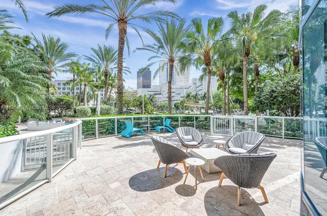 a view of a swimming pool with potted plants and palm trees
