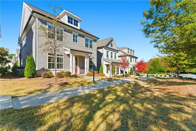 a front view of a house with a yard and car parked