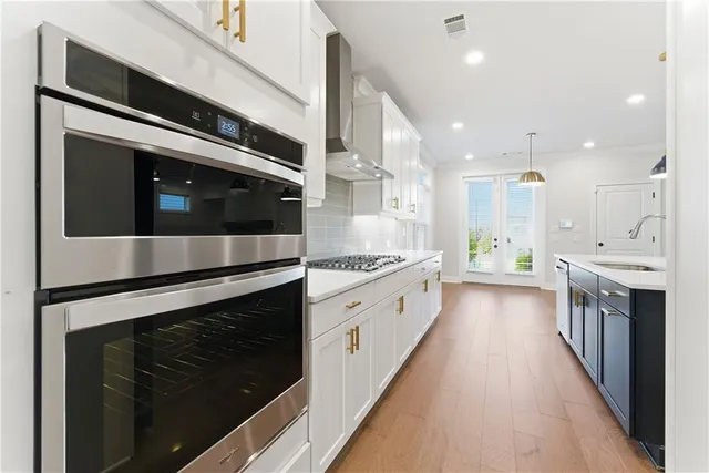 a kitchen with stainless steel appliances granite countertop white cabinets and a stove