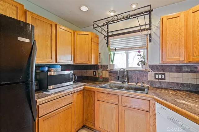 a kitchen with a refrigerator a sink and cabinets