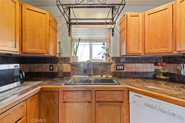 a kitchen with stainless steel appliances granite countertop a sink a refrigerator and cabinets