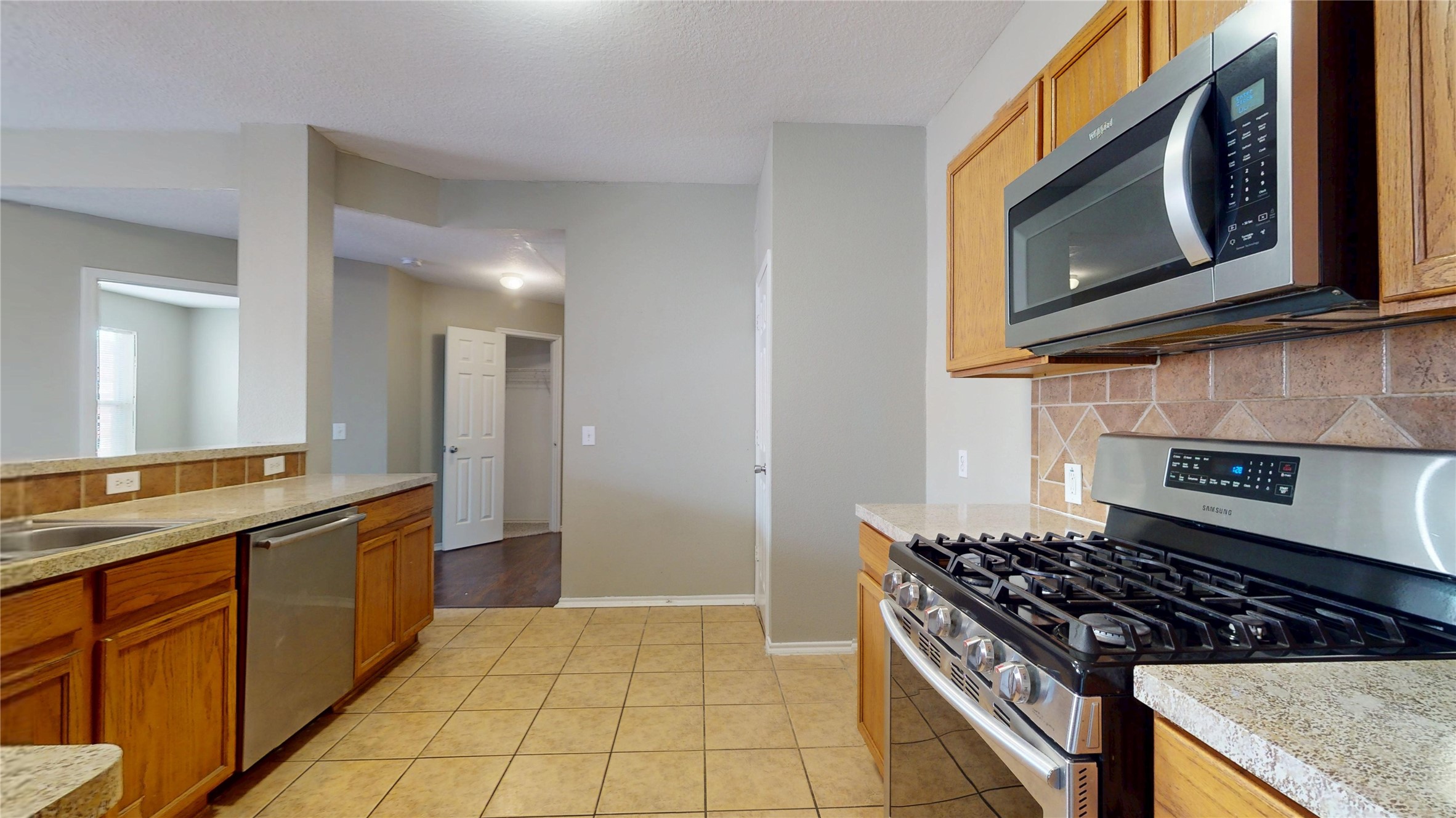 6007 Baldwin Elm Street Richmond, TX 77407 - Photo 12 of 45 a kitchen with stainless steel appliances granite countertop a stove and a microwave