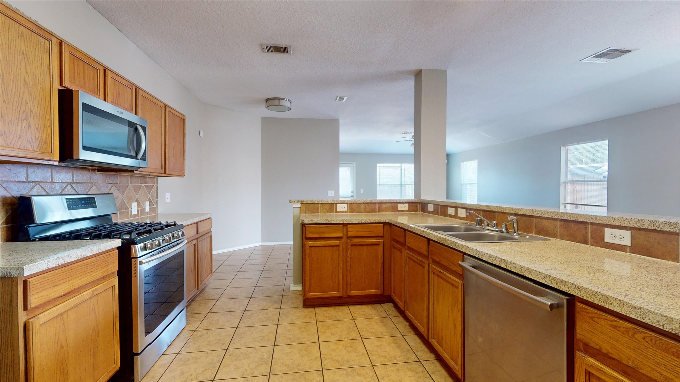 6007 Baldwin Elm Street Richmond, TX 77407 - Photo 16 of 45 a kitchen with stainless steel appliances granite countertop a stove a sink and a microwave