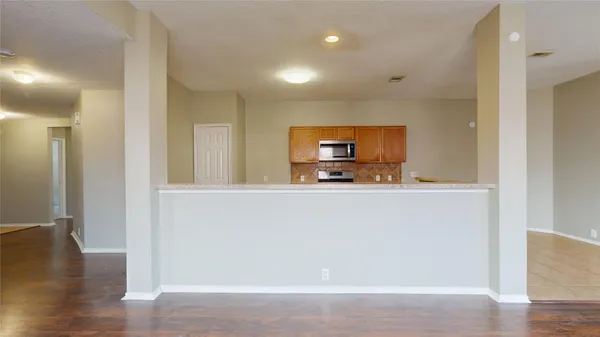 a kitchen with granite countertop a sink a stove top oven and cabinetry