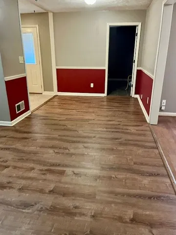 a view of room with window and wooden floor