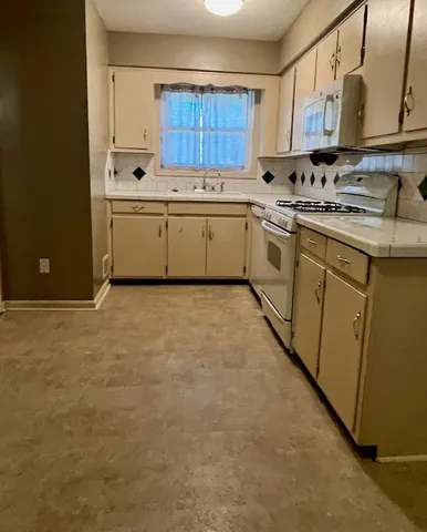 a kitchen with stainless steel appliances granite countertop a sink stove and cabinets