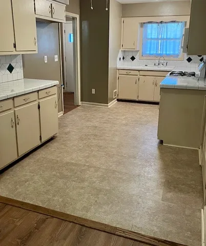 a kitchen with a sink a stove and cabinets