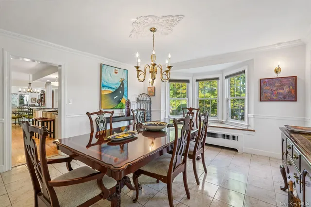 a dining room with furniture a chandelier and wooden floor