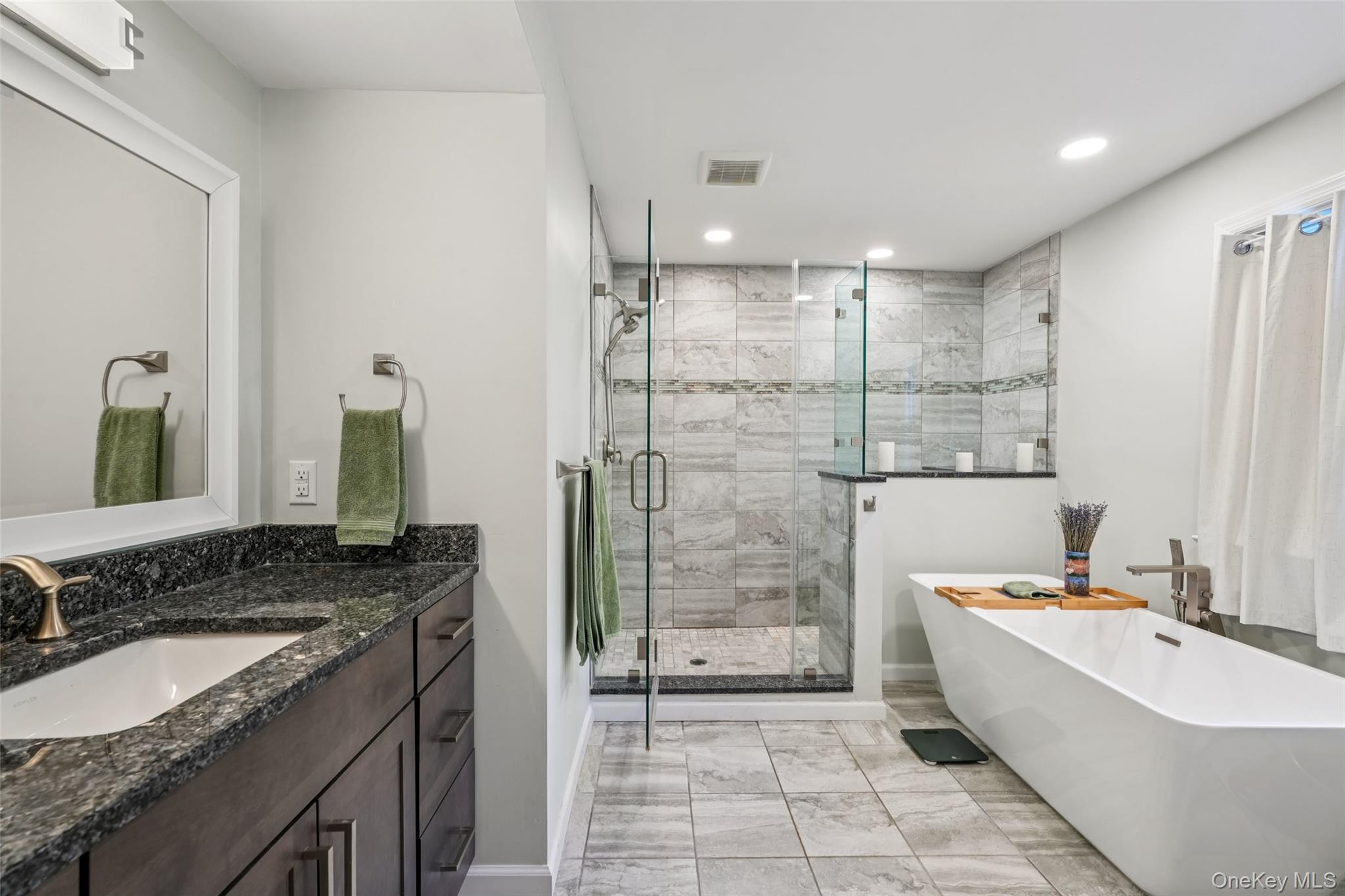 8 Abbey Road West Nyack, NY 10994 - Photo 20 of 38 a bathroom with a granite countertop double vanity sink a mirror a bathtub and shower