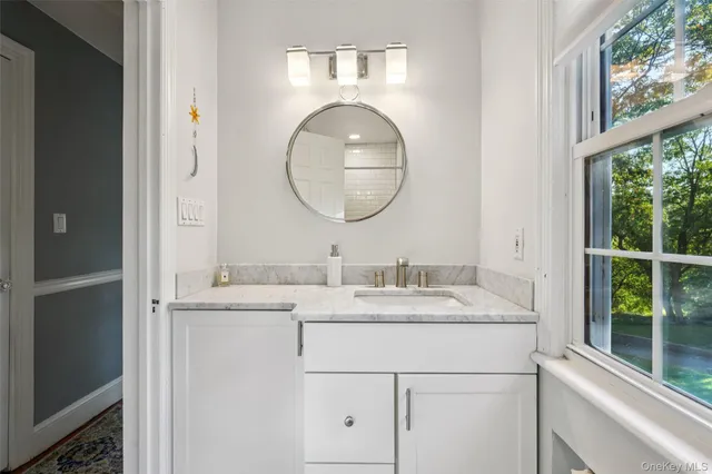 a bathroom with a granite countertop sink and a mirror