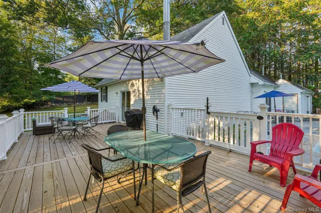 a view of deck with table and chairs under an umbrella