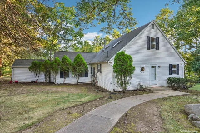 a view of a house with a yard and large tree