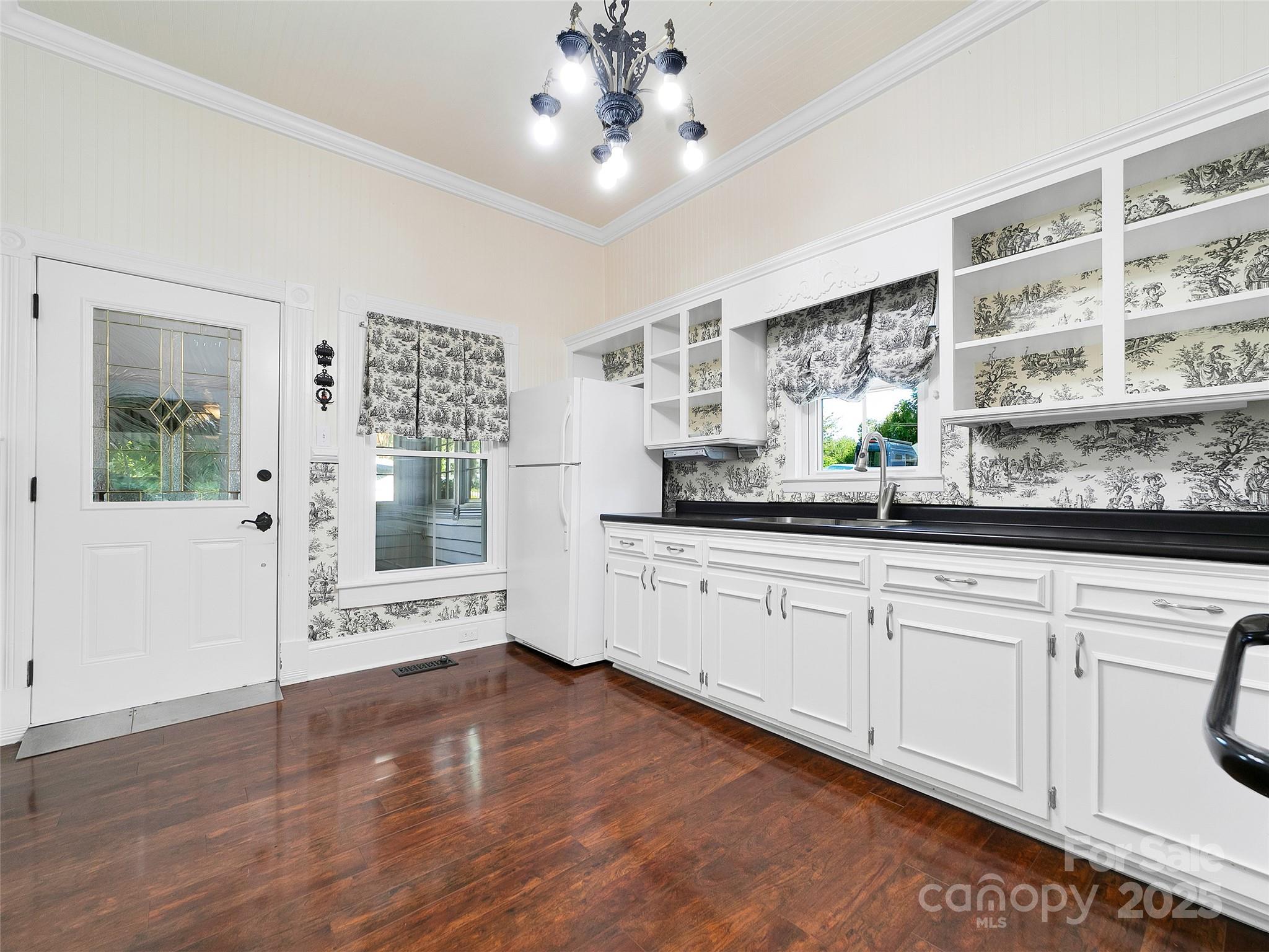 363 North Country Club Road Brevard, NC 28712 - Photo 13 of 42 a large white kitchen with granite countertop a stove a sink and white cabinets with wooden floor