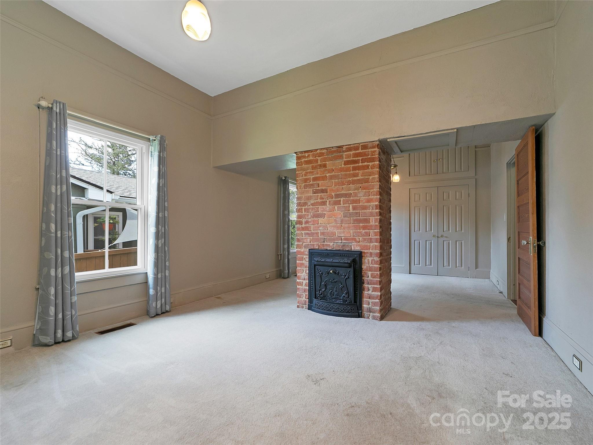363 North Country Club Road Brevard, NC 28712 - Photo 20 of 42 a view of an empty room with a fireplace and a window