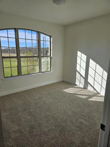 an empty room with a fireplace and windows